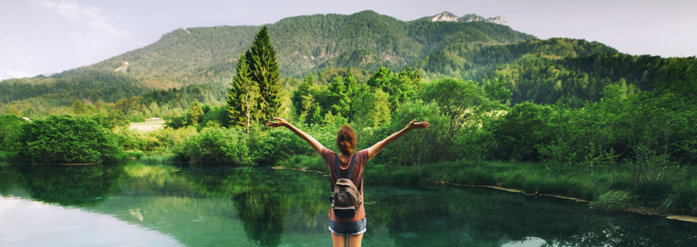 girl-in-front-of-lake-mountains-green-nature-areas