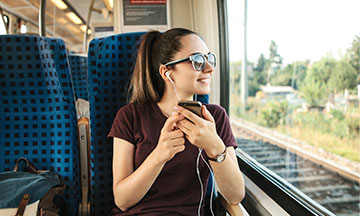 girl-in-train-listening-to-music-small