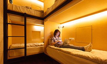 girl-in-hostel-on-bed-with-laptop