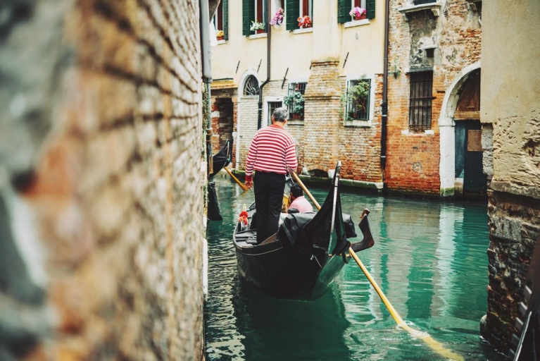 Traditionele gondel en gondelier op een kanaal in Venetië