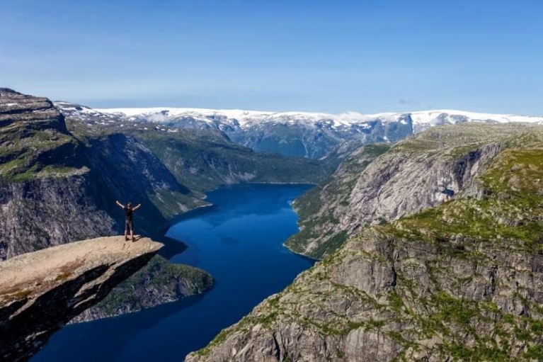 Man bovenop de Trolltunga in Noorwegen