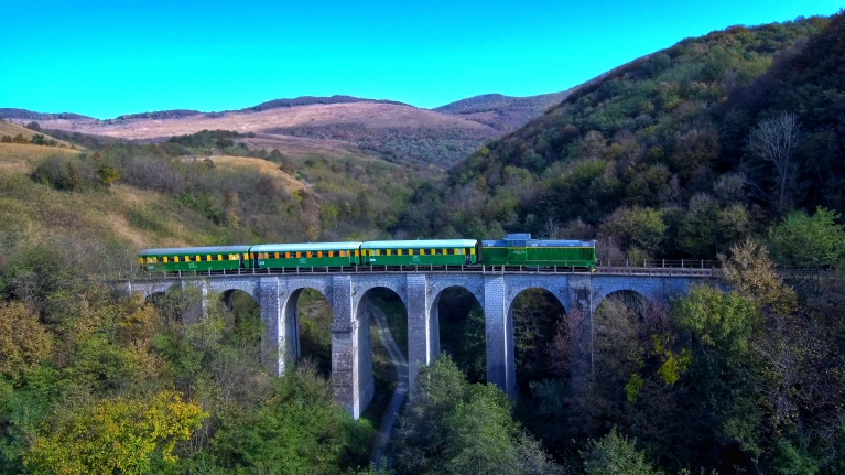 Een trein rijdt over een brug in Roemenië