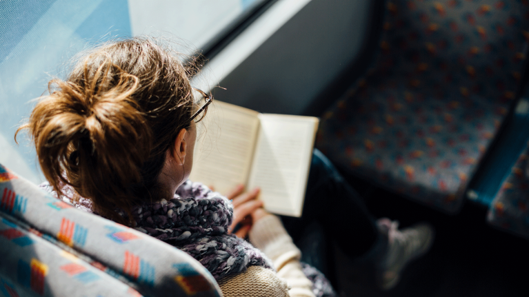 woman-travelling-in-train-reading-book