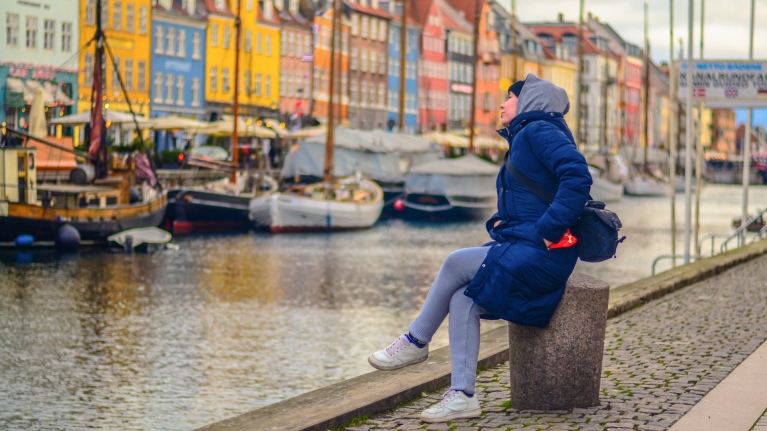 denmark-copenhagen-pier-nyhavn-woman-sitting